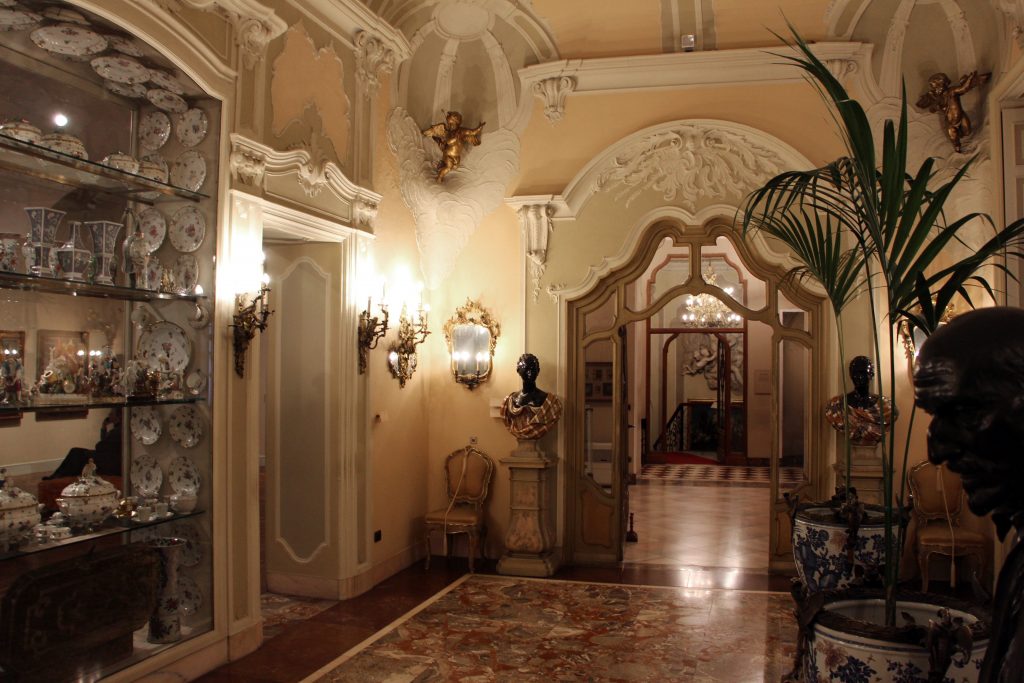 Sala di un museo con decorazioni in stucco e oro, statue e collezione di porcellane