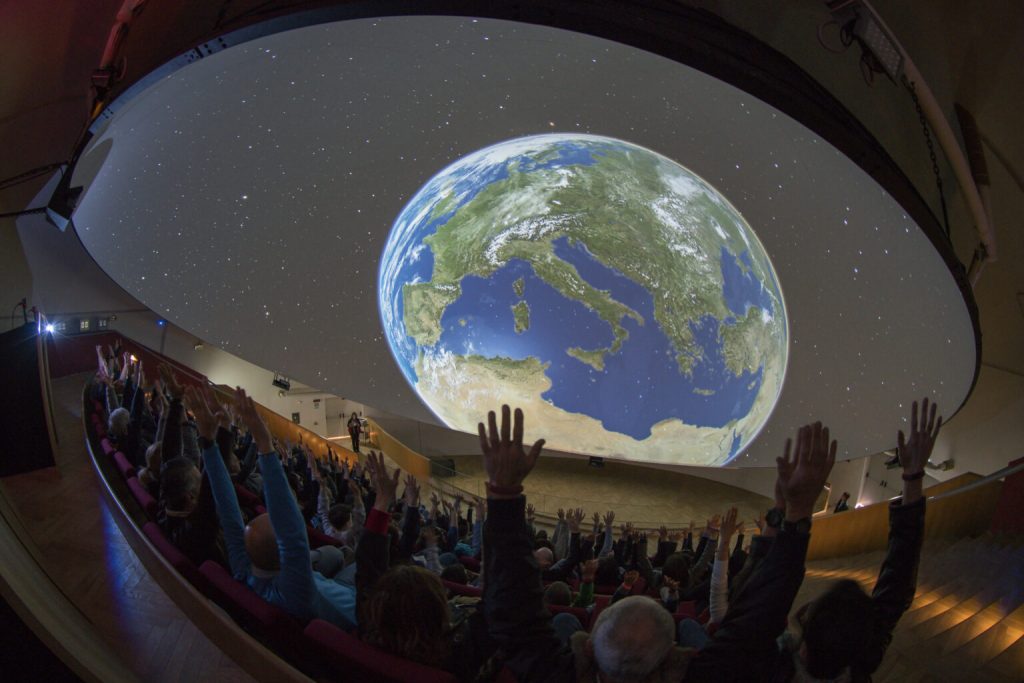 Bambini partecipano a un'attività didattica nel Planetario della Città della Scienza a Napoli