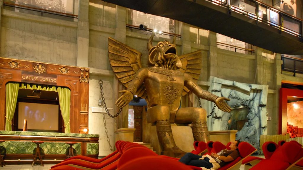 Scultura dorata di un drago in una sala con allestimento teatrale rosso