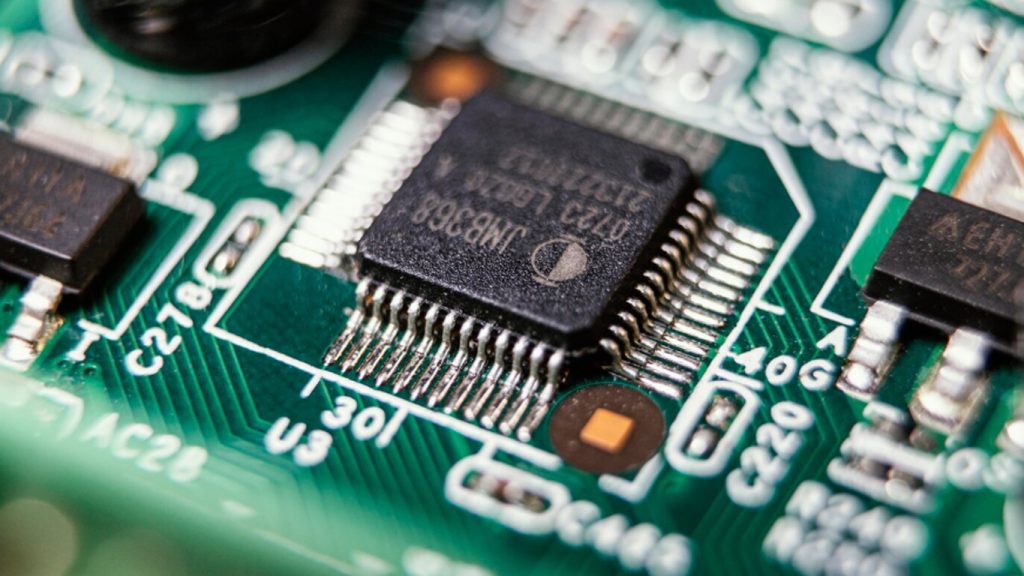 Microchip su una scheda elettronica verde in primo piano