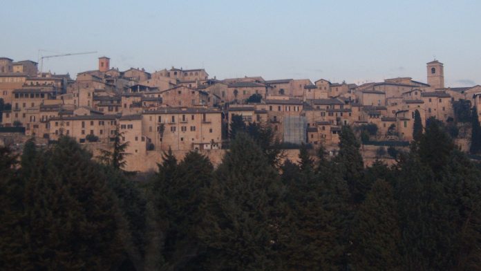 Veduta del borgo di Spello con case in pietra e campanili sul versante del Monte Subasio, in Umbria