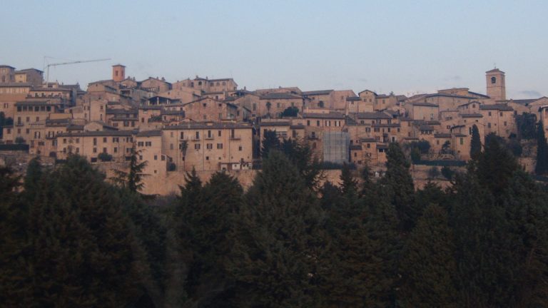 Veduta del borgo di Spello con case in pietra e campanili sul versante del Monte Subasio, in Umbria
